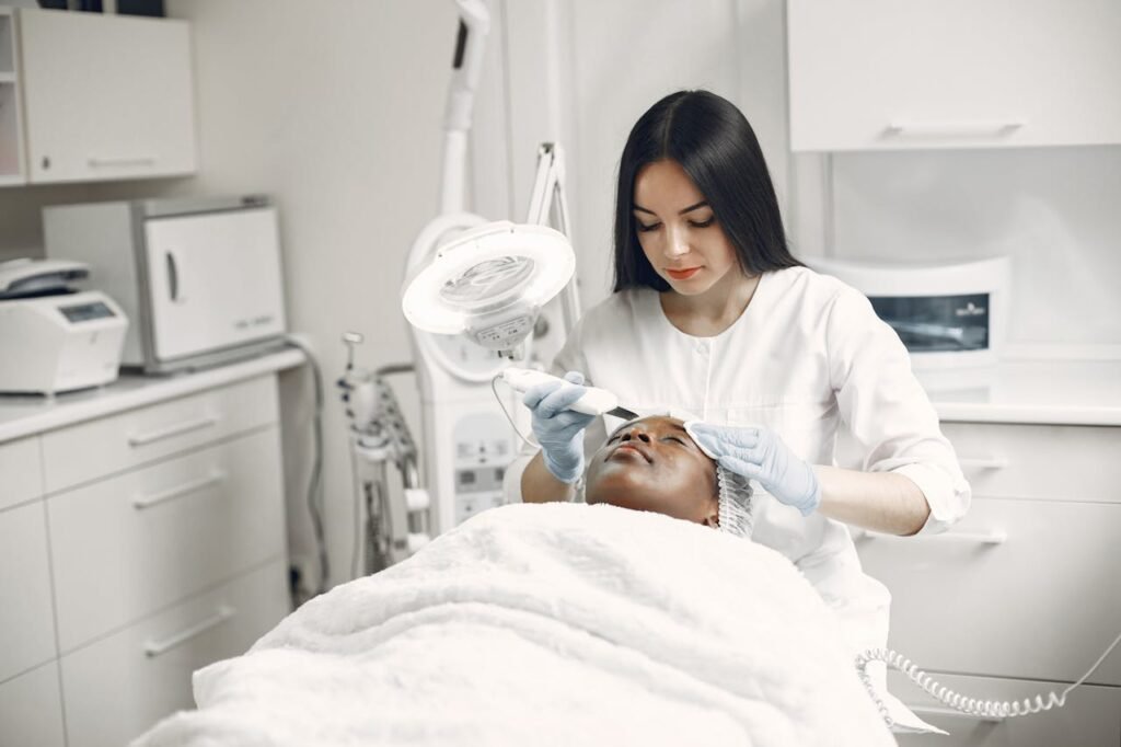 Aesthetician providing a rejuvenating facial treatment to a client in a modern spa clinic setup.